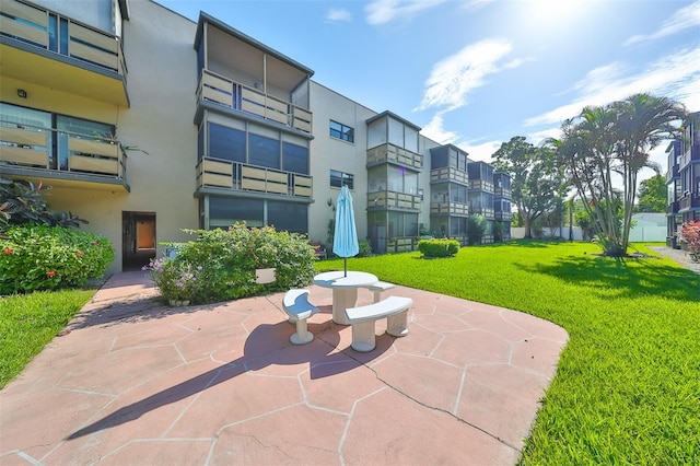 view of community with a patio and a lawn