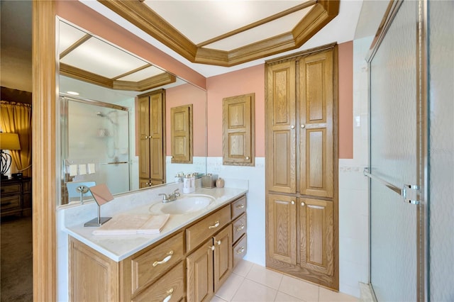 bathroom featuring tile walls, vanity, a shower with door, crown molding, and tile patterned floors