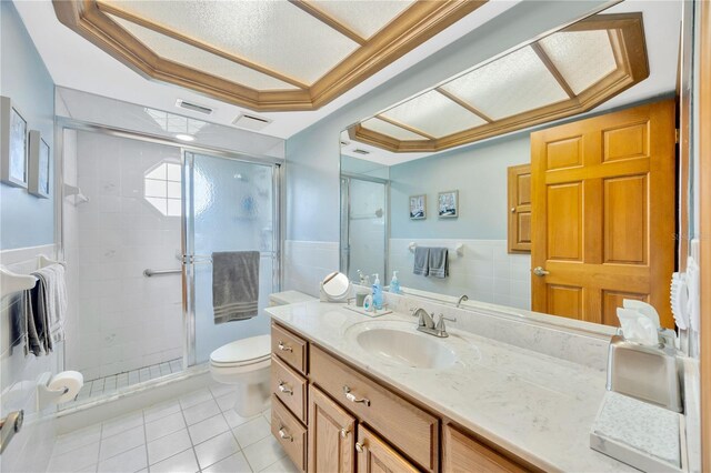 bathroom with vanity, a shower with shower door, tile patterned floors, and tile walls