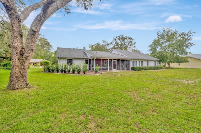 back of house with a lawn and a sunroom