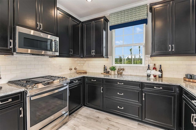 kitchen featuring stainless steel appliances, decorative backsplash, light wood-type flooring, ornamental molding, and light stone counters