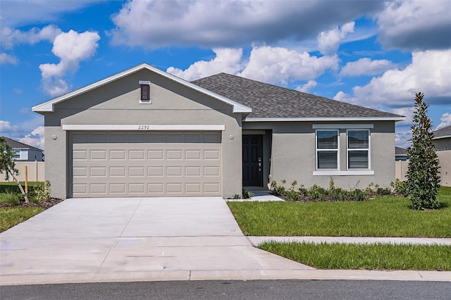 single story home featuring a garage and a front lawn