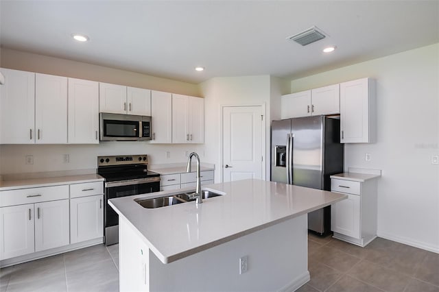 kitchen with sink, white cabinetry, appliances with stainless steel finishes, and an island with sink