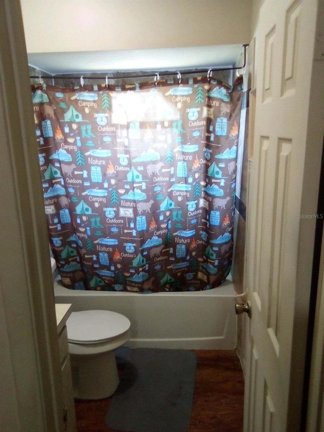 bathroom with shower / bathtub combination with curtain, vanity, and toilet