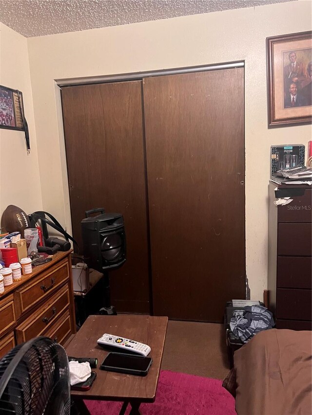 bedroom featuring a textured ceiling and a closet