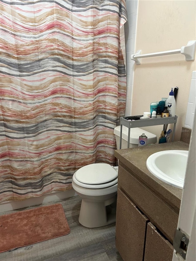 full bath featuring toilet, curtained shower, and vanity