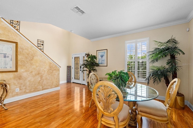 dining space with hardwood / wood-style flooring, french doors, and crown molding