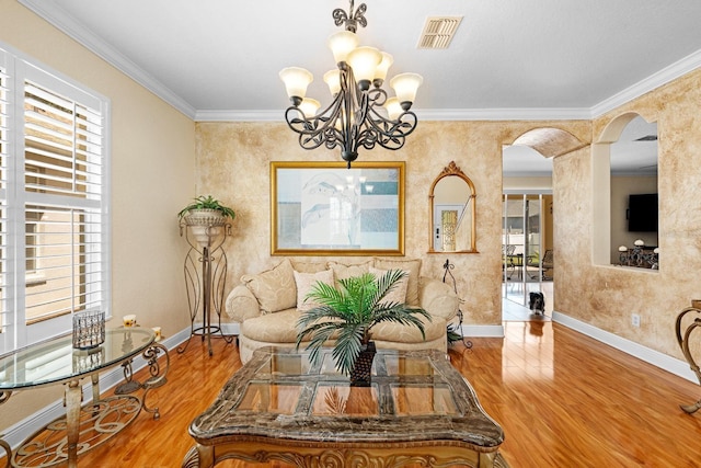 dining area featuring an inviting chandelier, hardwood / wood-style flooring, crown molding, and a healthy amount of sunlight