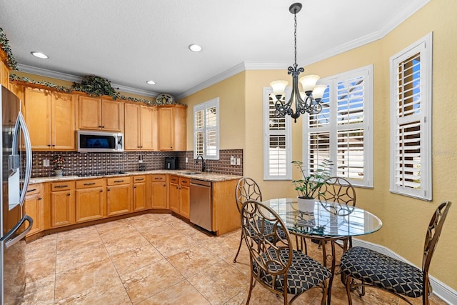 kitchen featuring pendant lighting, stainless steel appliances, ornamental molding, sink, and a chandelier