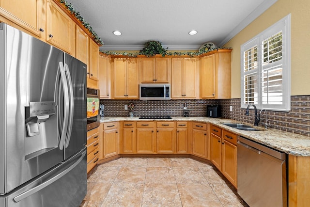 kitchen featuring light stone counters, stainless steel appliances, backsplash, and sink