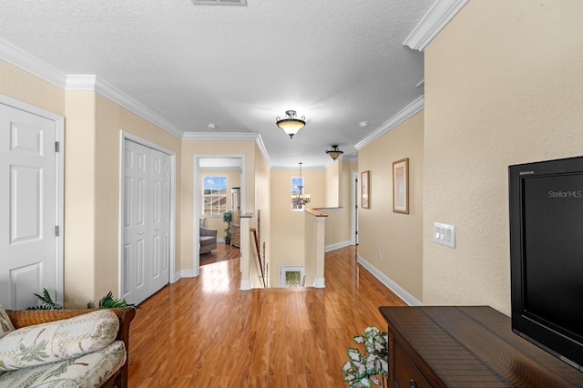 foyer entrance featuring wood-type flooring, a textured ceiling, and crown molding