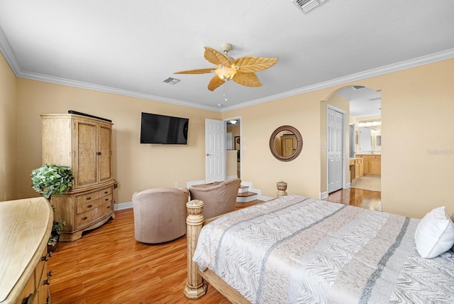 bedroom featuring a closet, light hardwood / wood-style floors, ensuite bath, ornamental molding, and ceiling fan