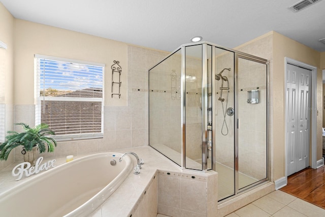 bathroom featuring independent shower and bath and hardwood / wood-style floors