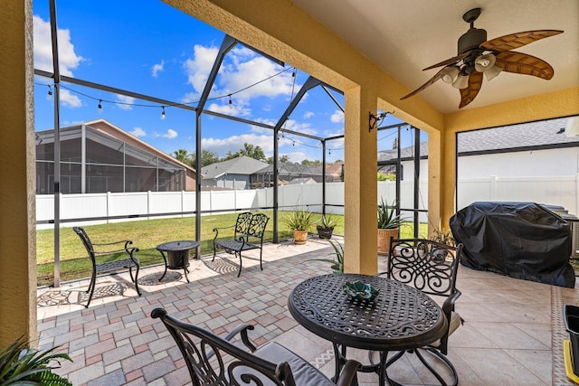 view of patio / terrace with a lanai, area for grilling, and ceiling fan