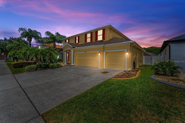 view of front of home with a garage and a lawn