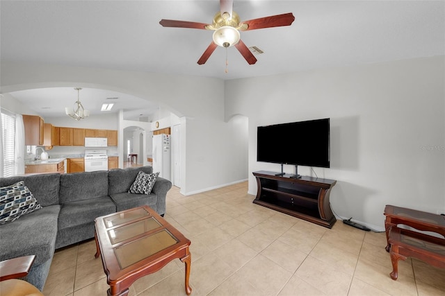 tiled living room featuring ceiling fan with notable chandelier