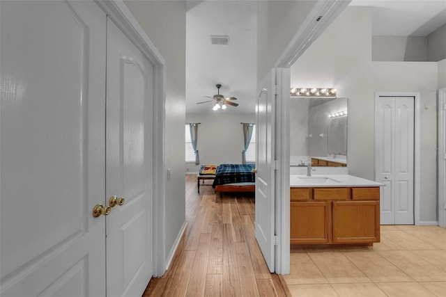 interior space featuring wood-type flooring, vanity, and ceiling fan