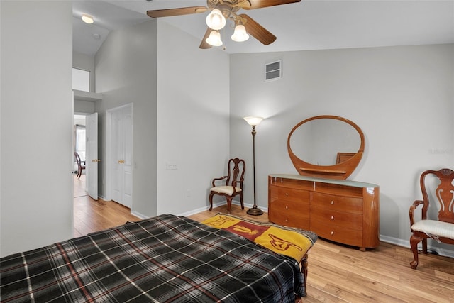 bedroom with light hardwood / wood-style flooring, ceiling fan, and high vaulted ceiling