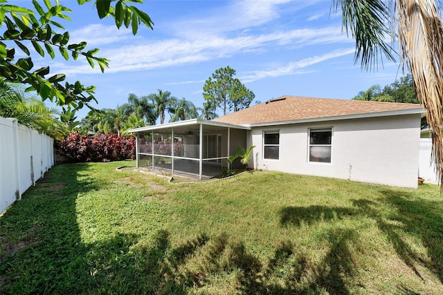 back of house featuring a sunroom and a yard