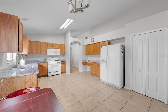 kitchen featuring white appliances, vaulted ceiling, light tile patterned floors, and sink