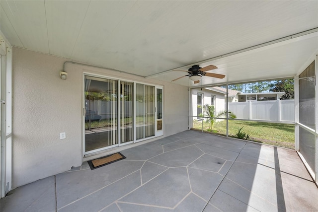 unfurnished sunroom featuring ceiling fan