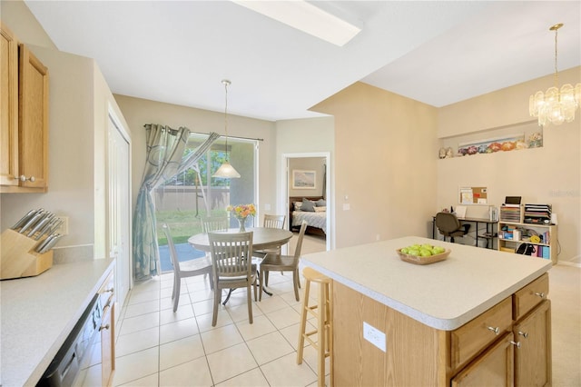 kitchen with light tile patterned floors, a breakfast bar area, decorative light fixtures, a chandelier, and a kitchen island