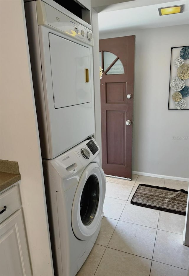 laundry room featuring light tile patterned flooring and stacked washer and clothes dryer