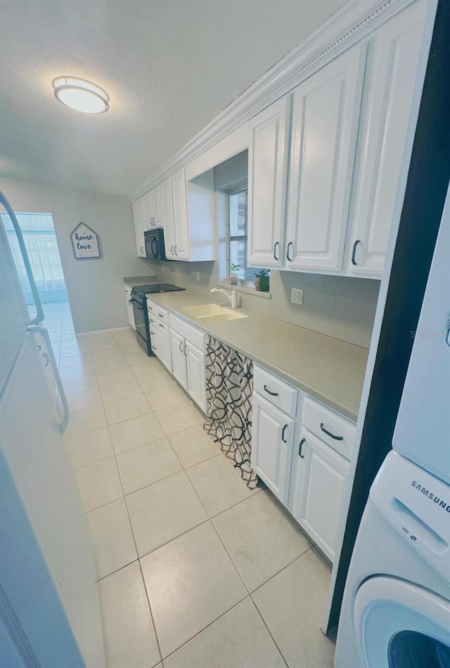 kitchen with white cabinets, black appliances, sink, and a wealth of natural light