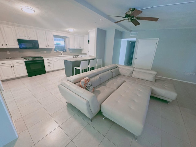 tiled living room with ceiling fan and sink