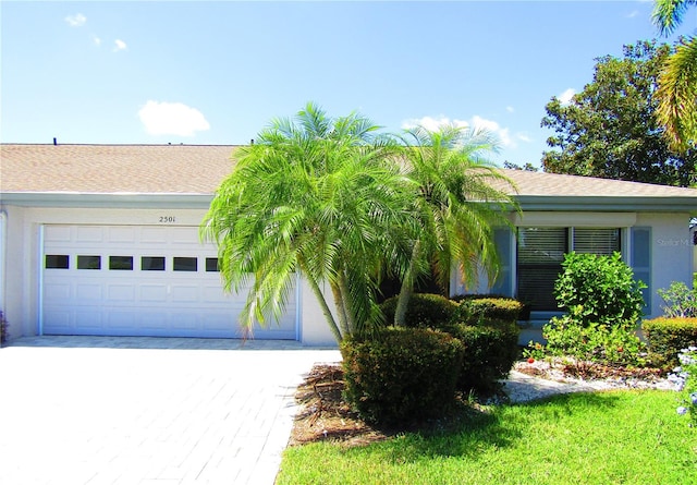 2501 Lonigan Pl, Sun City Center, FL 33573 - single story home with stucco siding, an attached garage, decorative driveway, and a shingled roof