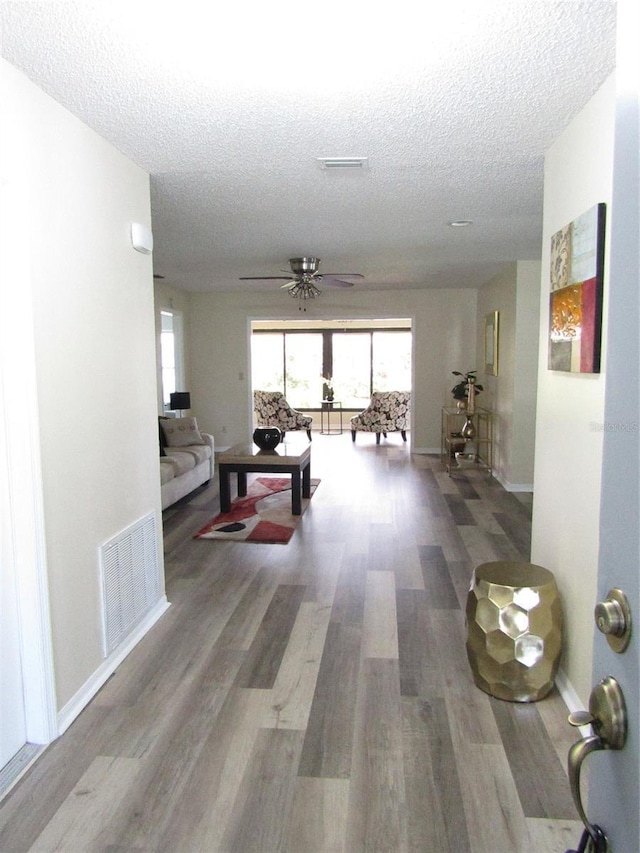 hall with a textured ceiling and hardwood / wood-style floors