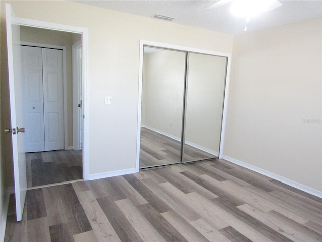 2501 Lonigan Pl, Sun City Center, FL 33573 - unfurnished bedroom with baseboards, wood finished floors, visible vents, and a closet