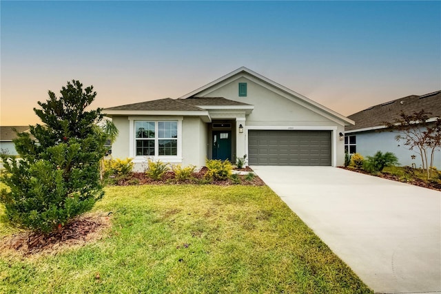 ranch-style house with a garage and a yard