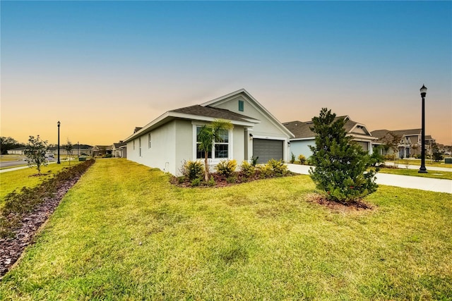 single story home with a garage and a lawn