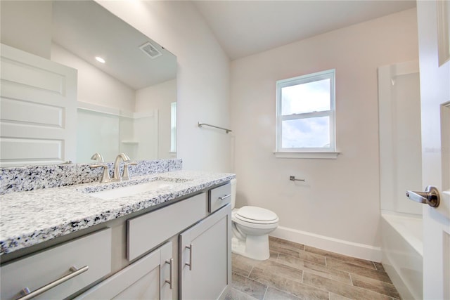 bathroom featuring vanity, vaulted ceiling, and toilet