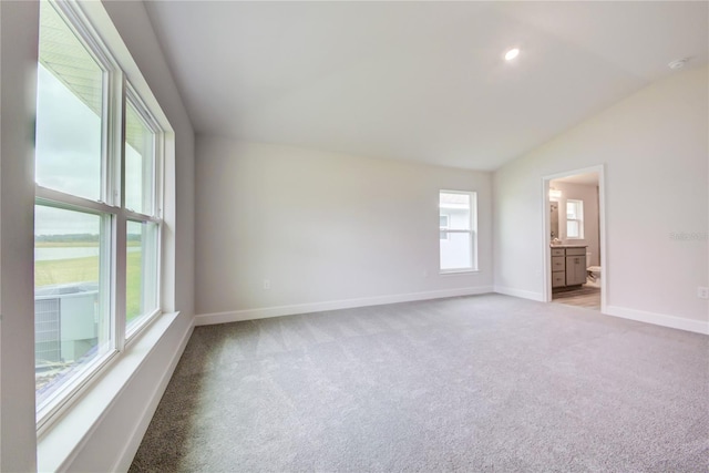 unfurnished room with lofted ceiling and light carpet