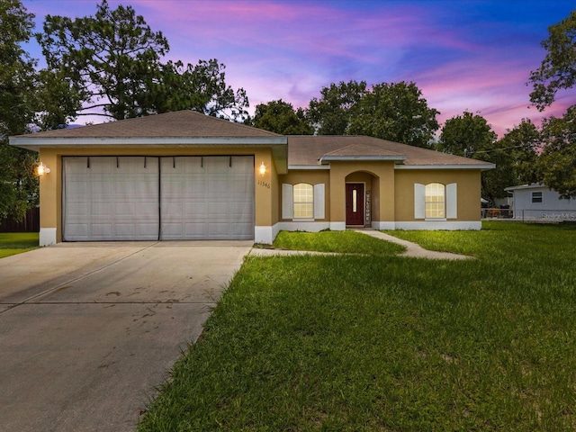 view of front of house with a garage and a lawn