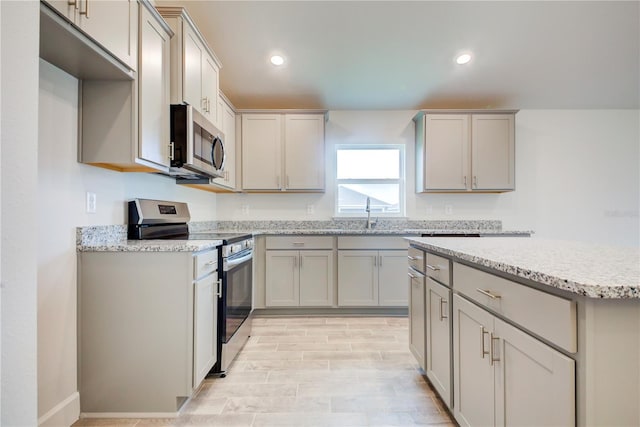 kitchen featuring gray cabinetry, sink, light hardwood / wood-style floors, and appliances with stainless steel finishes