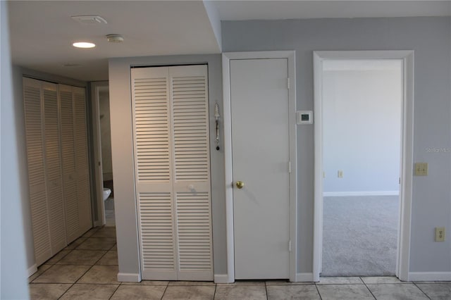 hall featuring light tile patterned floors