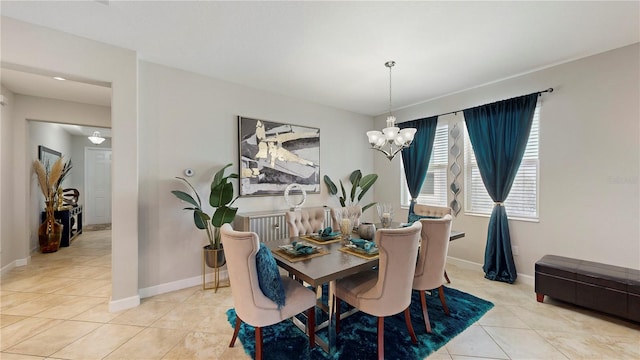 tiled dining room with a chandelier