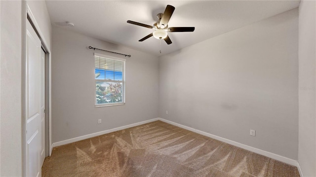 carpeted spare room featuring ceiling fan