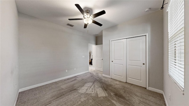 unfurnished bedroom featuring ceiling fan, a closet, and carpet flooring