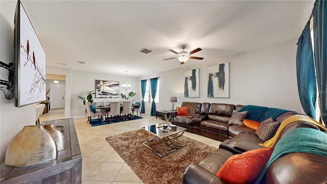 living room with ceiling fan with notable chandelier and light tile patterned flooring