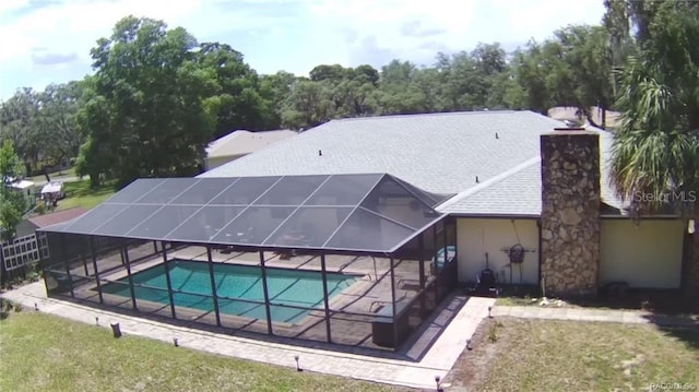 view of pool featuring a lanai, a patio area, and a lawn