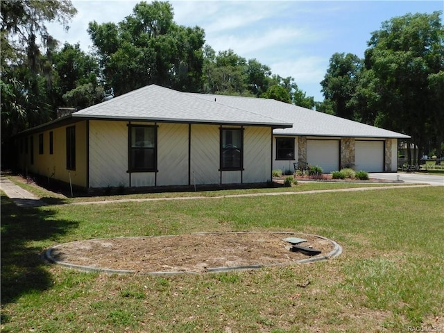 ranch-style home featuring a garage and a front lawn