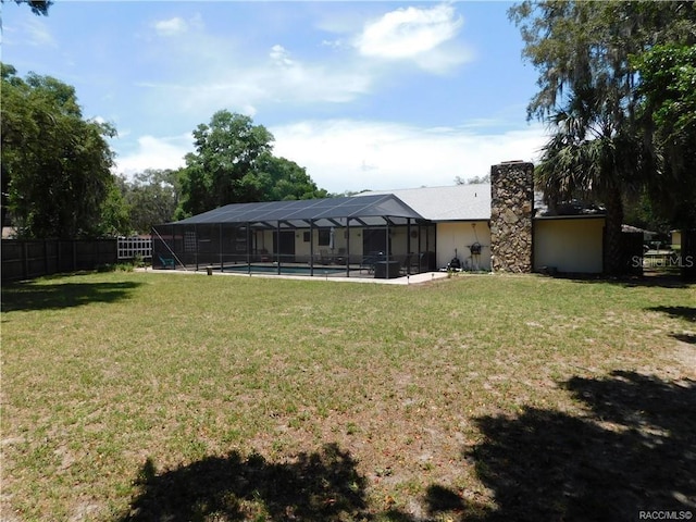 view of yard with a fenced in pool and glass enclosure