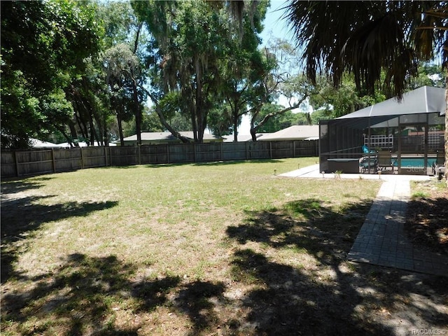 view of yard featuring a lanai, a fenced in pool, and a patio area