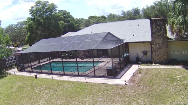 view of pool with a patio, a lanai, and a lawn