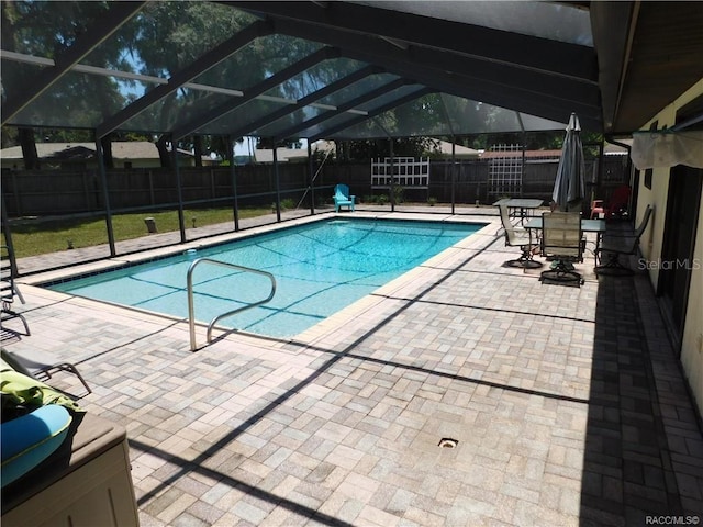 view of swimming pool featuring a patio and glass enclosure