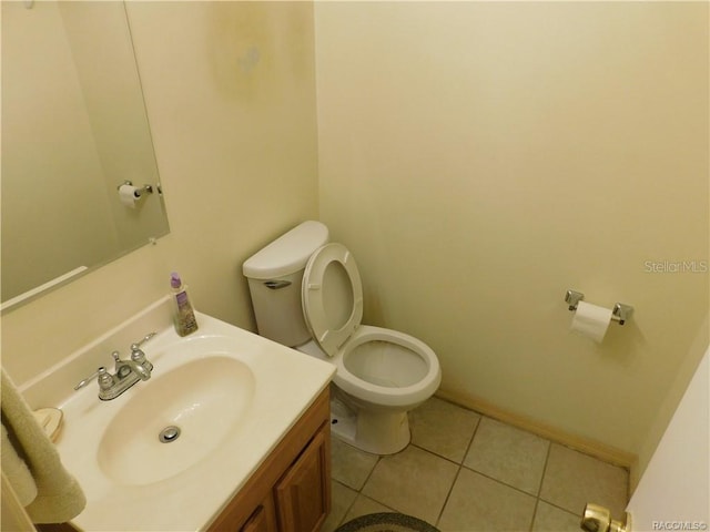 bathroom with tile patterned flooring, vanity, and toilet